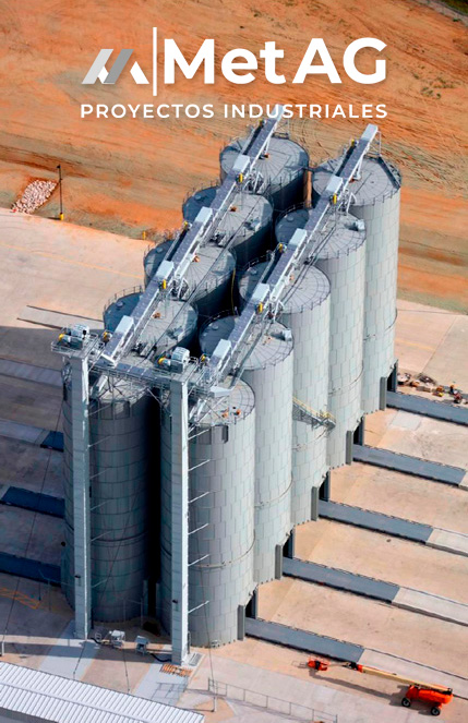 metag-proyectos-industriales-silos-de-almacenamiento-alineados-planta-industrial-exterior-paisaje-cálido-con-logo-de-MetAG-fábricas-ingeniería